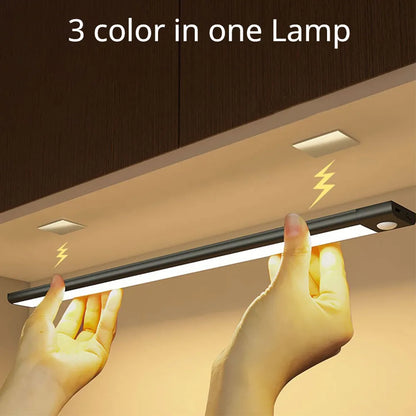 Light strip with '3 color in one Lamp' text held by hands against a wooden cabinet background.